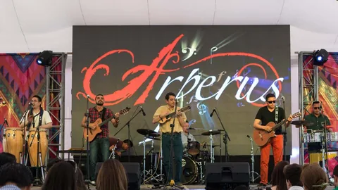 Presentación del grupo ante una pantalla con el logo de Arperus